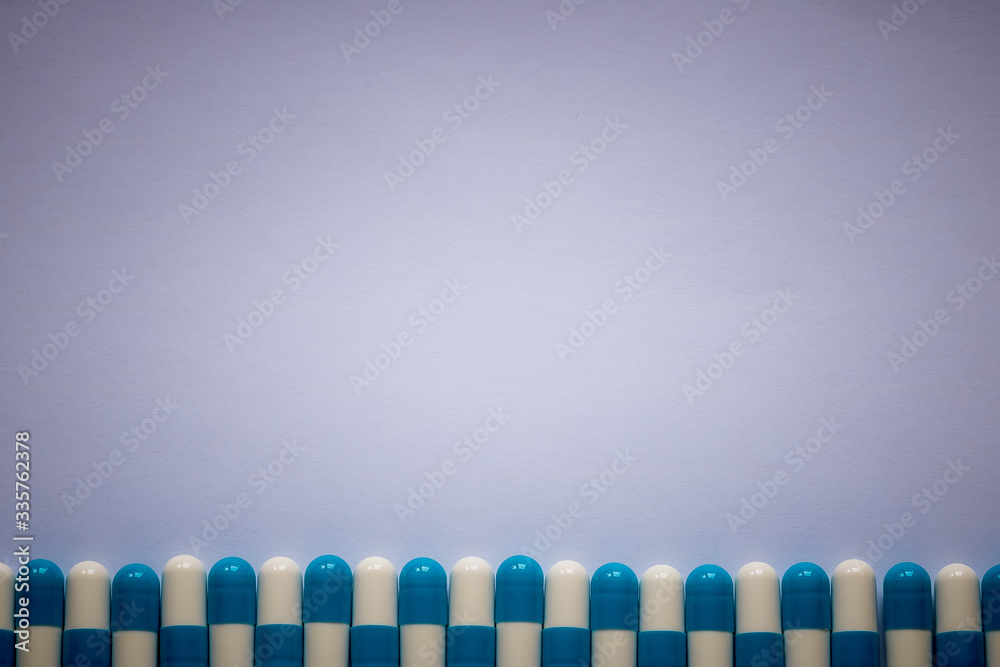 blue-white pills lined up against a plain background
