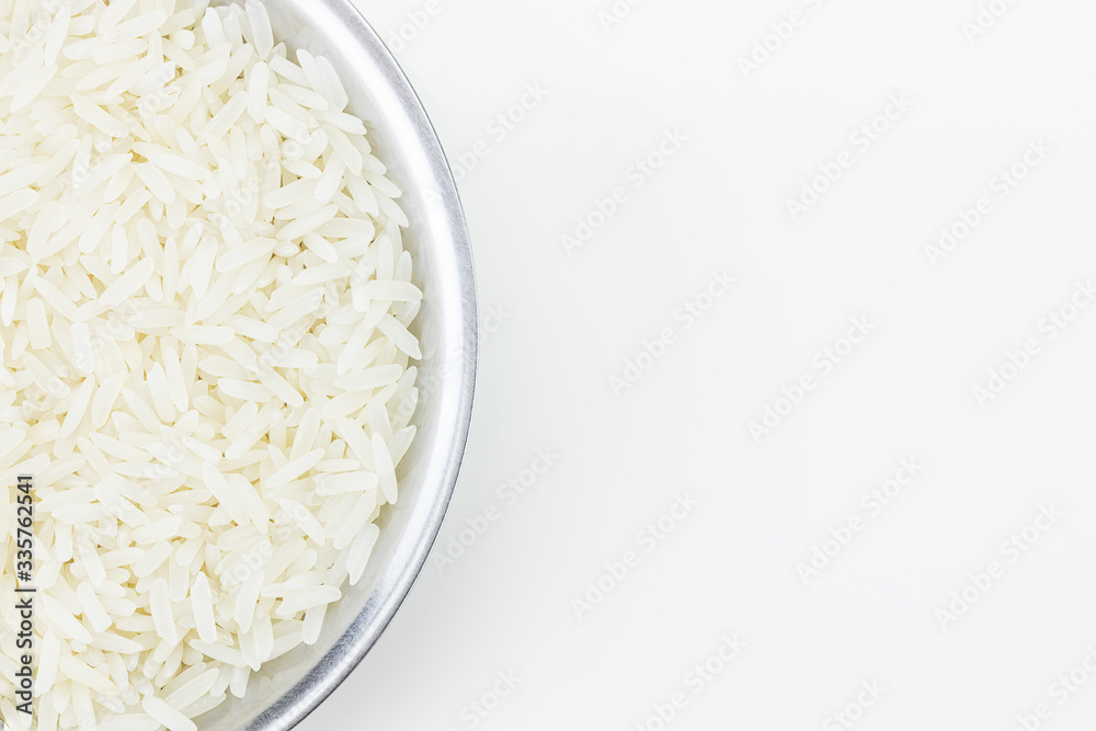White uncooked thai Jasmine rice in metal bowl on white background White uncooked thai Jasmine rice in metal bowl on white background