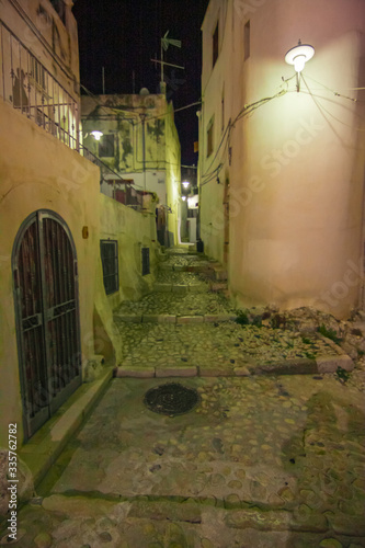 Night view of a picturesque view of the streets of the historic center of the ancient seaside village of the city of Peschici on the Gargano in Italy.