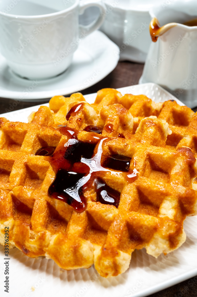 Tasty Belgian dessert, homemade Brussels sugar waffles with dark syrup Tasty Belgian dessert, homemade Brussels sugar waffles with dark syrup