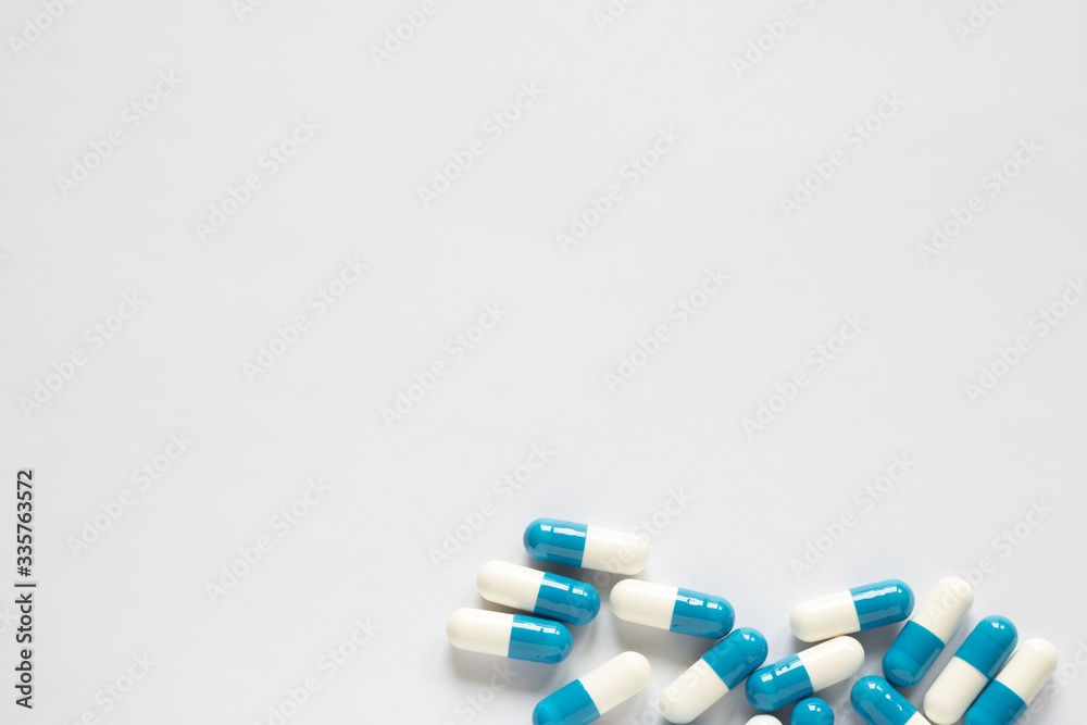 blue-white pills on a plain background blue-white pills on a plain background
