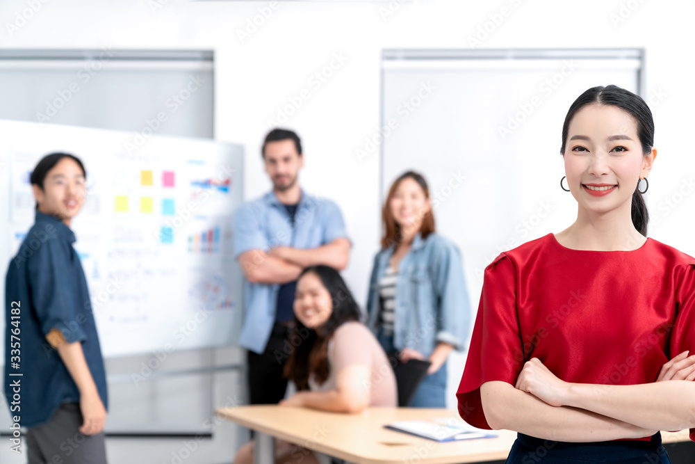 Obraz premium Smart asian startup small entrepreneur standing confident portrait with friends partner casual meeting brainstorm with white board and business financce paper chart anslysis in office background