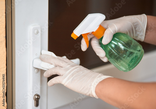 Decontaminating the surface of the door handle. Coronavirus prevention, hygiene to stop spreading coronavirus.