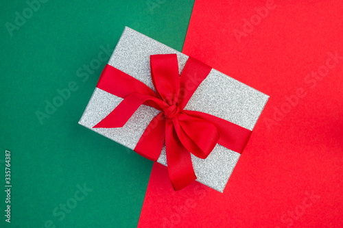 Red and green paper texture, silver glitter gift box with red ribbon on it, background for template, horizontal