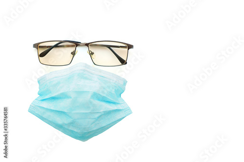 metal-framed glasses with tinted glasses and a medical surgical mask on a white background. Concept of a doctor or a man during a pandemic or epidemic of coronavirus, flu, colds..