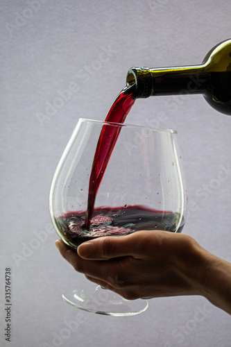 wine pouring into a glass on a white background