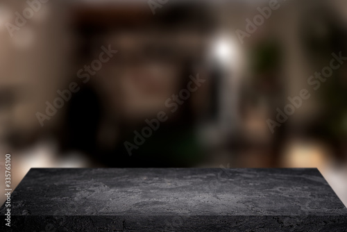 Black stone surface on blurry background with spots.