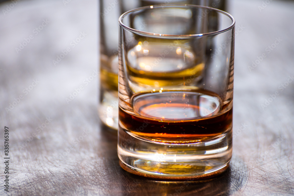 Tasting of flight of Scotch whisky from tumbler glasses in old Edinburgh pub,  Scotland, UK