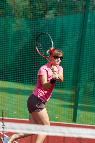Female tennis player hitting a two-handed backhand © ffolas