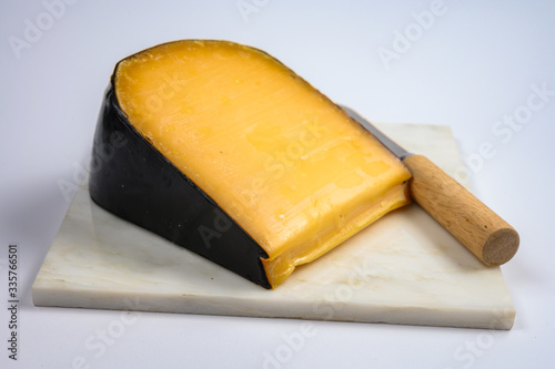 One piece of old Dutch gouda cheese with black wax