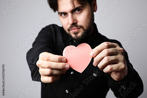 Portrait of bearded man holding a heart sign. Relationship concept.