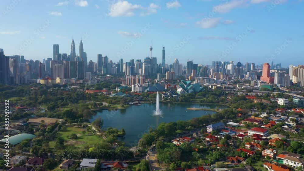 February 23rd, 2020 - Kuala Lumpur, Malaysia : 4k Establishing b-roll aerial shot of drone moving forward towards Kuala Lumpur city skyline. Flying over Titiwangsa Lake. Green and Sustainable City