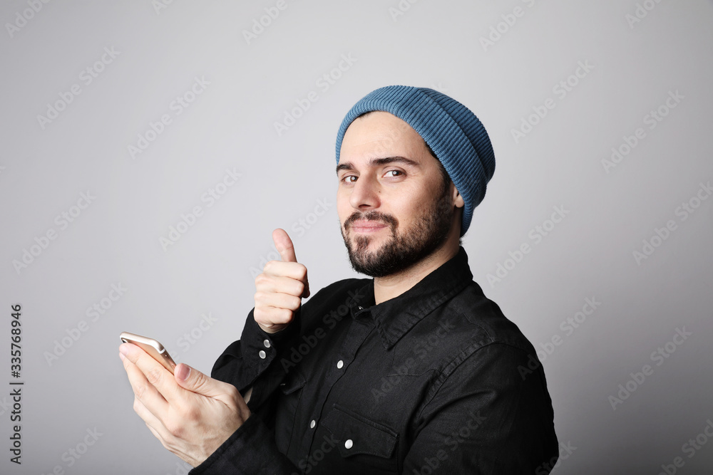 Handsome and bearded hipster wearing stylish hat on head. Brutal man with mustache and beard on unshaven bearded face. Handsome and bearded hipster wearing stylish hat on head. Brutal man with mustache and beard on unshaven bearded face.