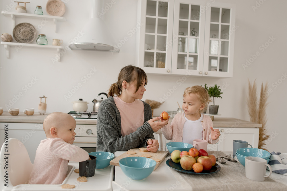 A young mother spends time with her little daughters at home.