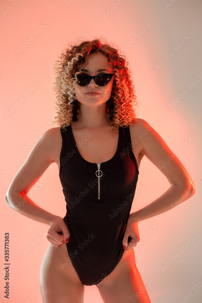 Young sexy blonde woman posing in a fashionable swimsuit. Girl with a perfect body. Studio shot.