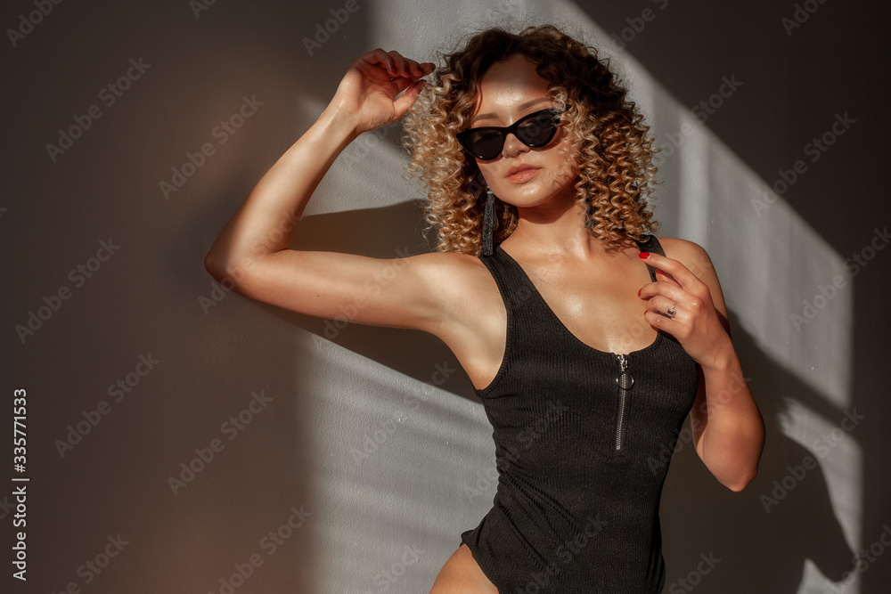 Young sexy blonde woman posing in fashionable swimsuit. Girl with ideal body. Studio shot.