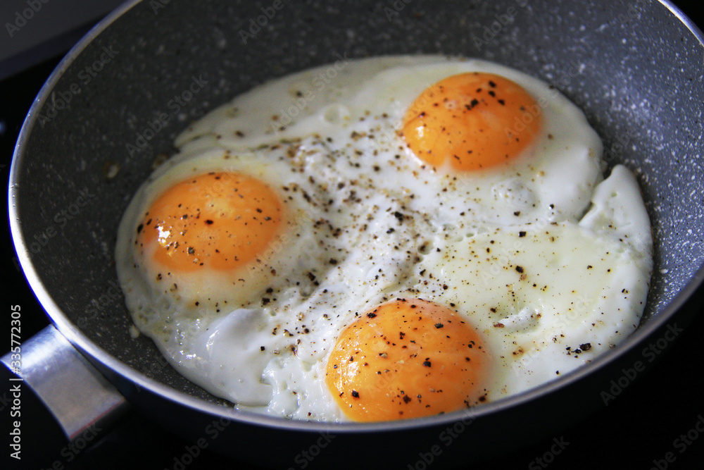 three baked eggs in frying pan three baked eggs in frying pan