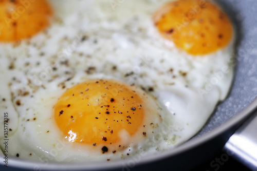 three baked eggs in frying pan