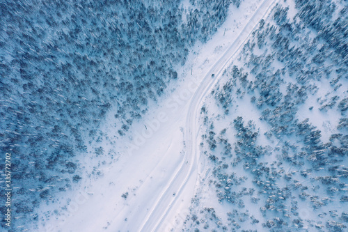 Aerial view of snow covered pine forest and road. Frozen day in Siberia © Annatamila