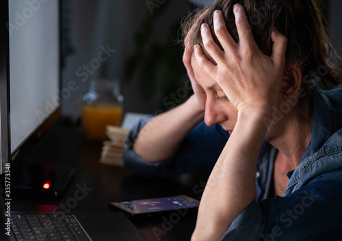 depressed woman working from home holding her head