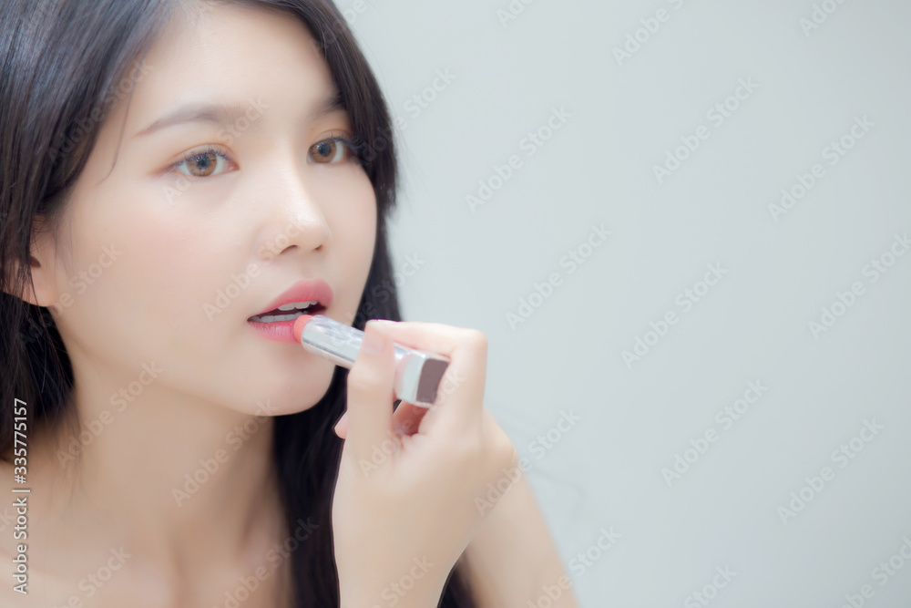 Beautiful young asian woman applying lipstick pink with style bright and shiny on mouth, beauty girl looking mirror for makeup cosmetic with lip elegance, fashion make up with luxury and sexy. Beautiful young asian woman applying lipstick pink with style bright and shiny on mouth, beauty girl looking mirror for makeup cosmetic with lip elegance, fashion make up with luxury and sexy.
