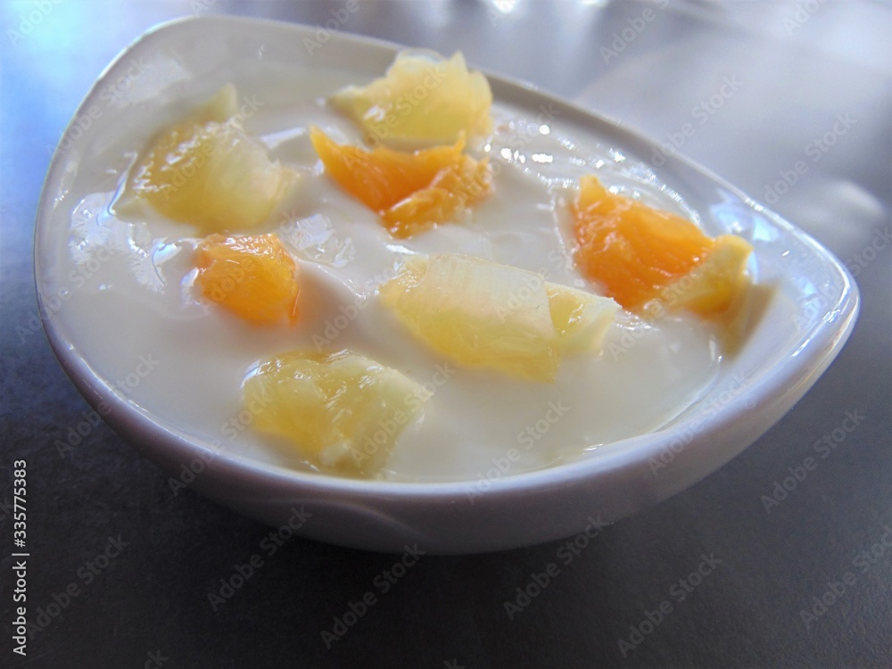 Yoghurt with citrus fruits in a bowl. Sour cream, yogurt with fresh orange and lemon, close up. Yoghurt with citrus fruits in a bowl. Sour cream, yogurt with fresh orange and lemon, close up.