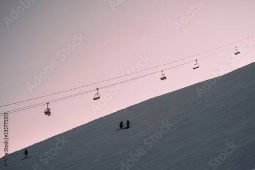 Ski lift above ski slop in resort during sunset