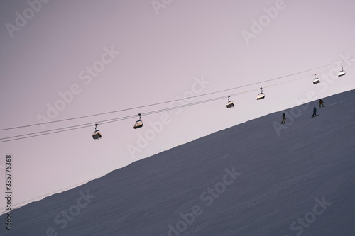Ski lift above ski slop in resort during sunset