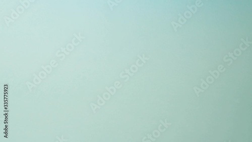 Fresh green apple being taken by female hand out of the frame. Blue background