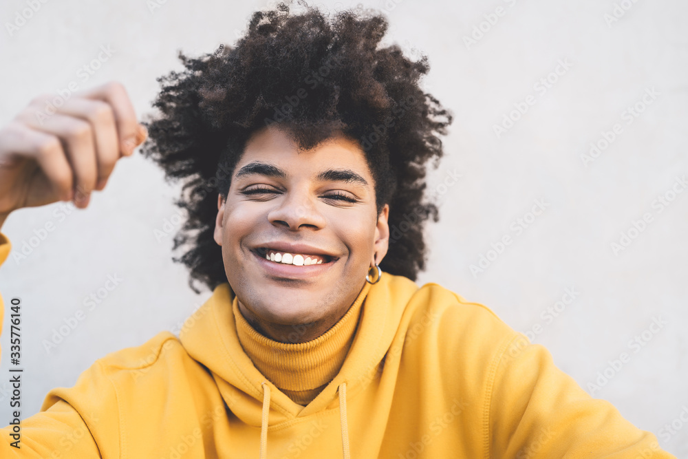 Afro smiling man portrait - Mixed race young guy having fun posing in front camera - Youth millennial generation culture and multiracial people concept Afro smiling man portrait - Mixed race young guy having fun posing in front camera - Youth millennial generation culture and multiracial people concept