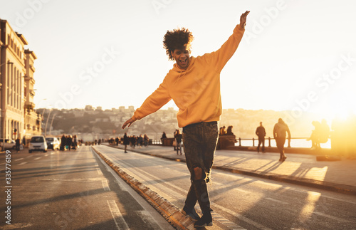 Afro American man having fun walking in city center - Happy young guy enjoying time a sunset outdoor - Millennial generation lifestyle and positive people attitude concept