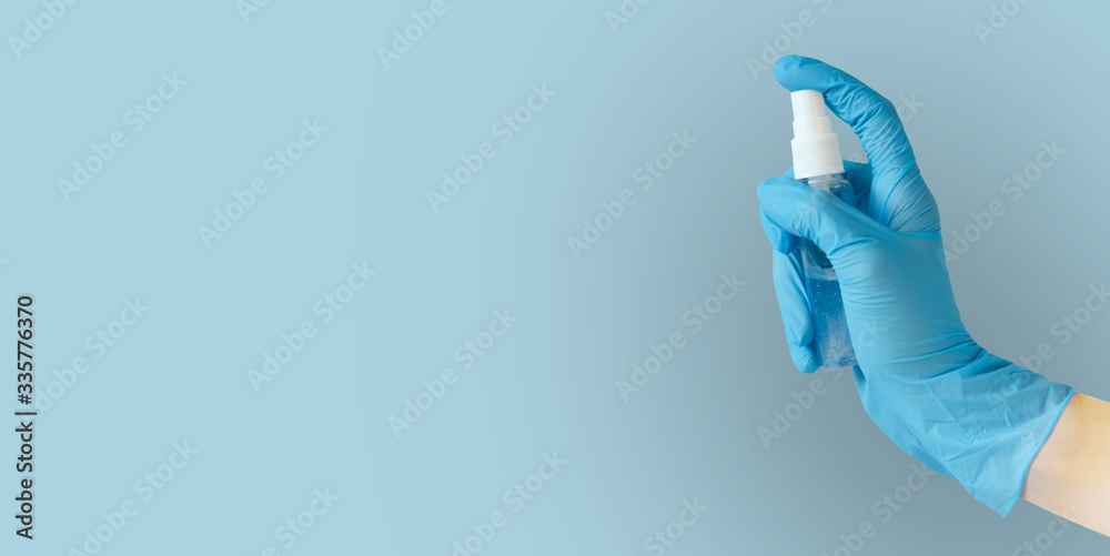 Hand in blue medical gloves holding sanitizer spray Hand in blue medical gloves holding sanitizer spray