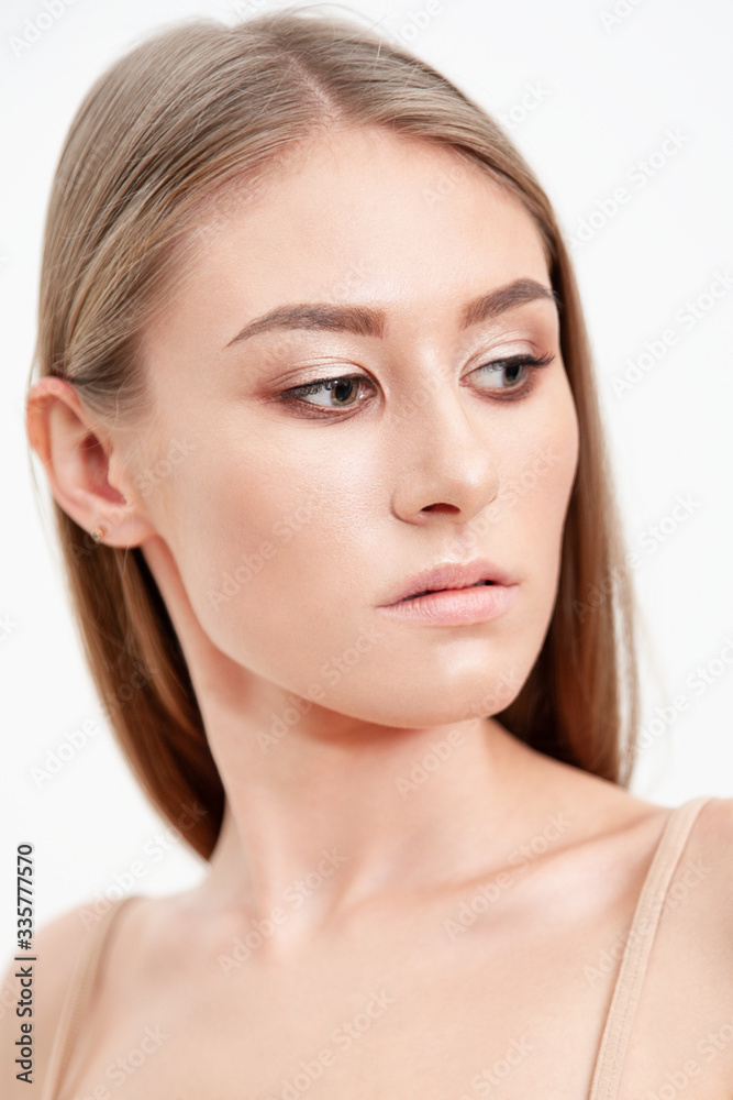Portrait of a pretty blonde girl with nude makeup