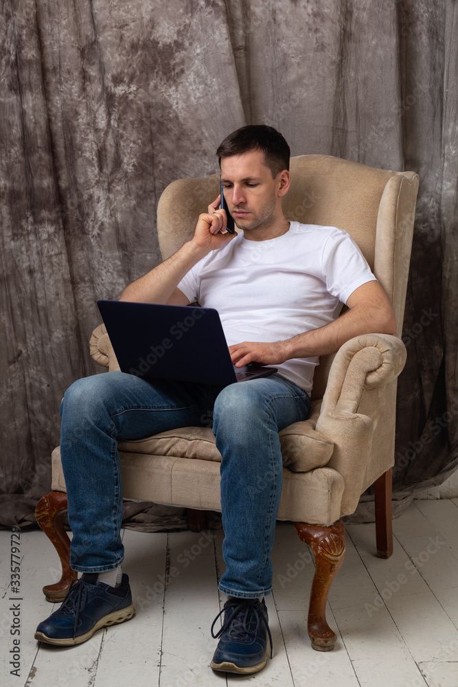Young man sitting comfortably and talking on the phone