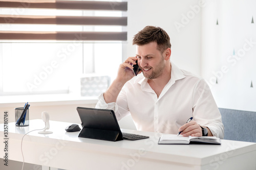 Caucasian male working from home office and talking on the phone