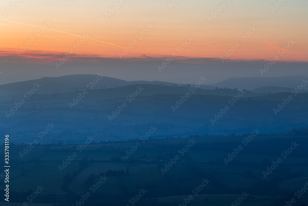 Red Clouds over Hazy Countryside Fields