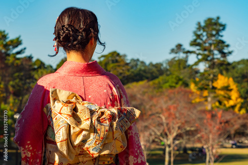 Japan. Geisha admires Nara Park. A girl in a kimono on the background of autumn trees. Autumn in Japan. National costume. Kimono. Japanese women's clothing. Natural attractions of Japan.