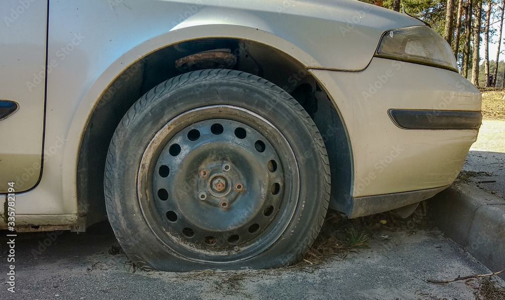Flat tire and rusted wheel in a car parked for a long time