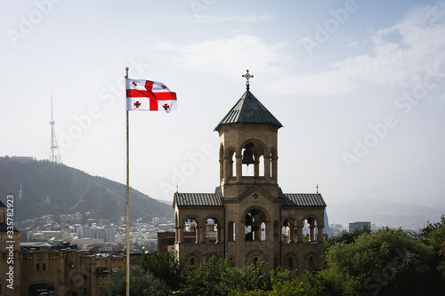 Quadro su tela Bell Tower with georgian flag near Holy Trinity Cathedral of Tbilisi also known