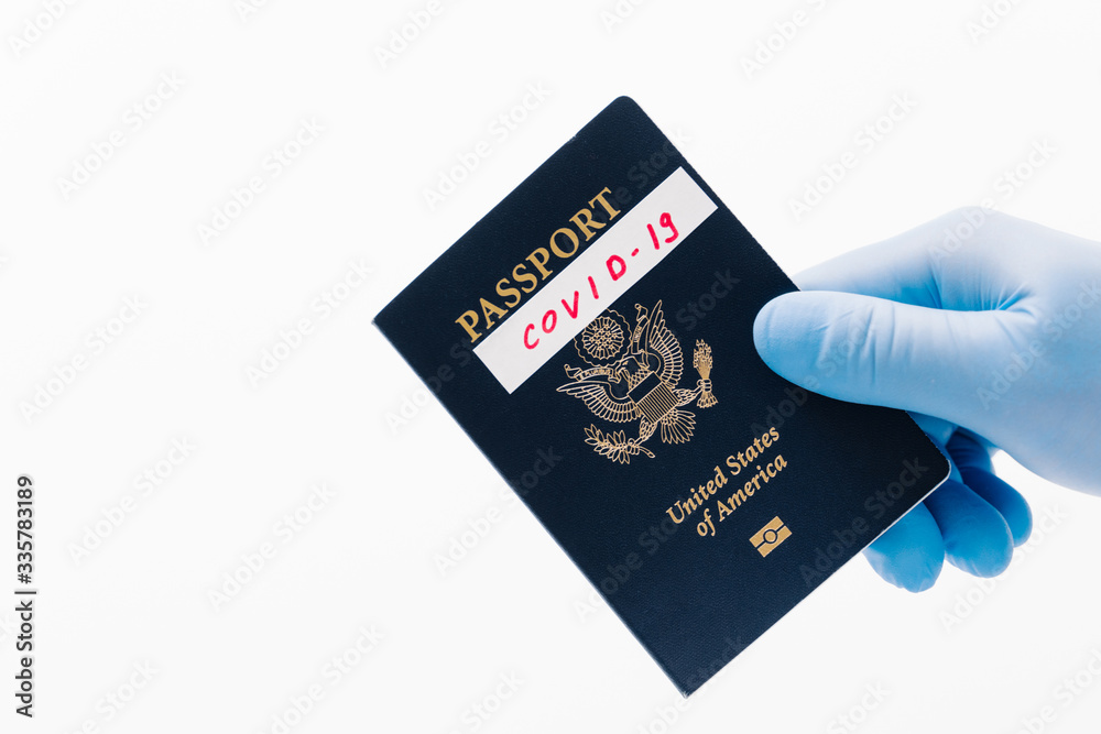 Coronavirus outbreak and travel concept. Passport in humans hand wearing rubber medical gloves, isolated on white background. Self isolation for tourists Coronavirus outbreak and travel concept. Passport in humans hand wearing rubber medical gloves, isolated on white background. Self isolation for tourists