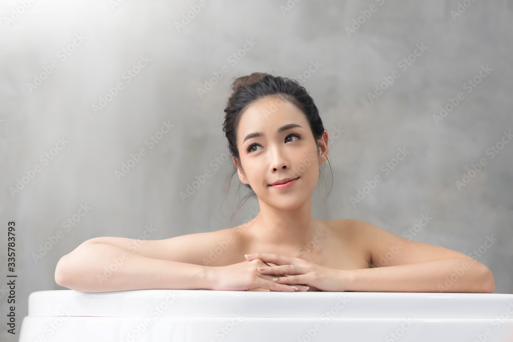 Smiling Beautiful Asian girl relaxing in the tub at the home. Smiling Beautiful Asian girl relaxing in the tub at the home.