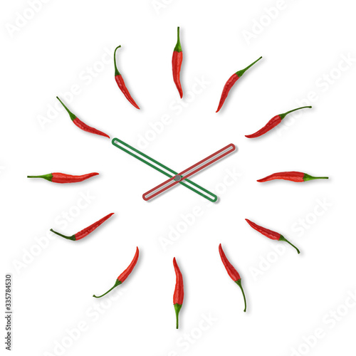 Red chili pepper arranged as a clock on a white background