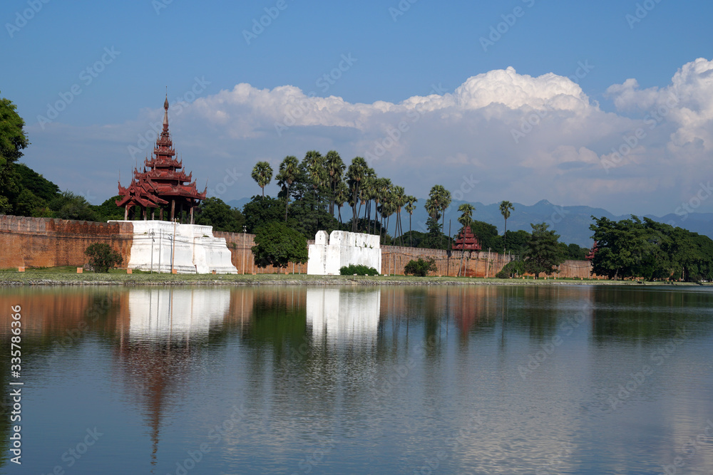 Landscape Ancient brown brick Palace wall with sugar palm tree and Moat surrounding of Mandalay palace located in Mandalay, Burma (Myanmar) - Historical Travel Concept Landscape Ancient brown brick Palace wall with sugar palm tree and Moat surrounding of Mandalay palace located in Mandalay, Burma (Myanmar) - Historical Travel Concept