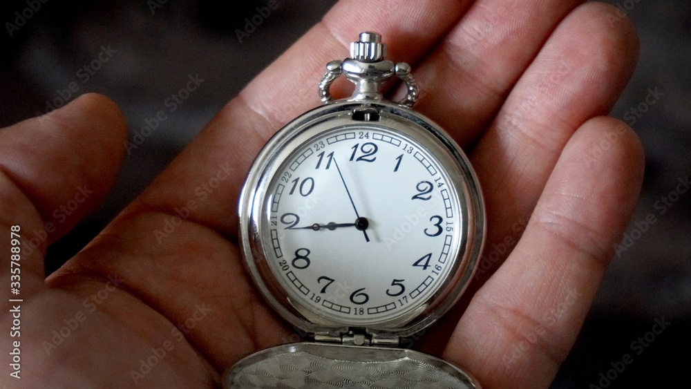 Old antique pocket watch showing time being held in hand. Close up Old antique pocket watch showing time being held in hand. Close up
