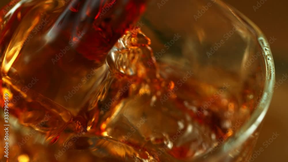 Super slow motion of pouring whiskey in super macro shot. Filmed on high speed cinema camera, 1000fps Super slow motion of pouring whiskey in super macro shot. Filmed on high speed cinema camera, 1000fps