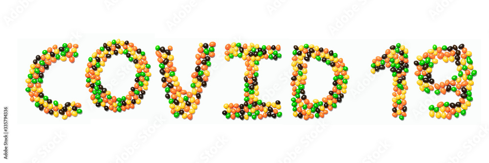 Inscription Covid 19 of the English alphabet   from multicolored round chocolates on a white isolated background.Meal and medical  pattern.Sign  coronavirus from a photo of children's candy