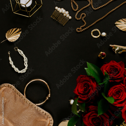 Luxury golden accessories for women's beauty. Dating concept with red lipstick, roses, golden chain, earrings and handbag on black background. Elegant modern template for feminine identity. Flat lay
