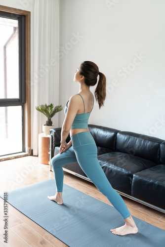 A young Asian woman doing yoga at home