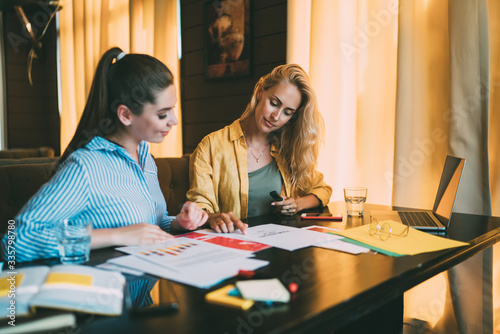 Businesswomen researching documents in workspace during remote job