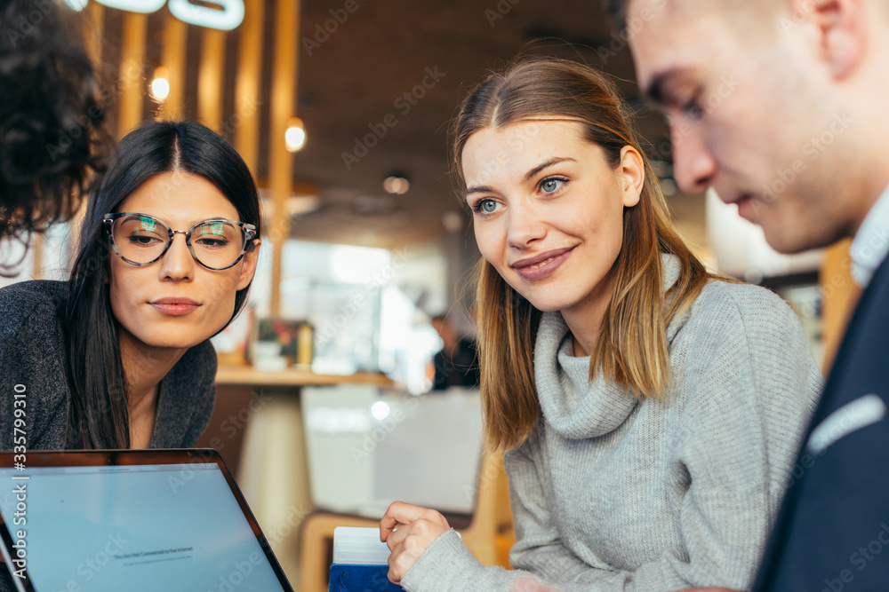 Group of young multiethnic friends bonding and having fun in a coffee shop